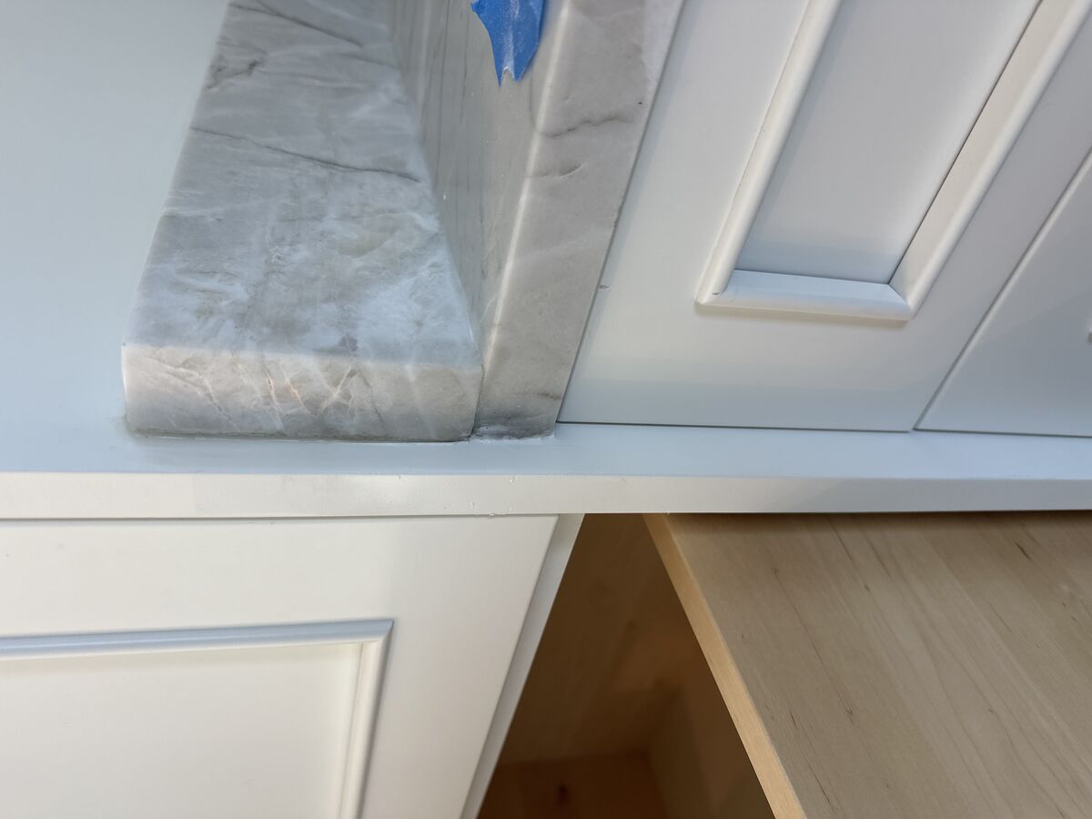 Kitchen with marble countertop and refinished cabinets